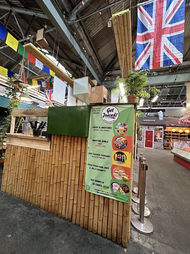 Bamboo stall frontage with bunting hanging from the market roof