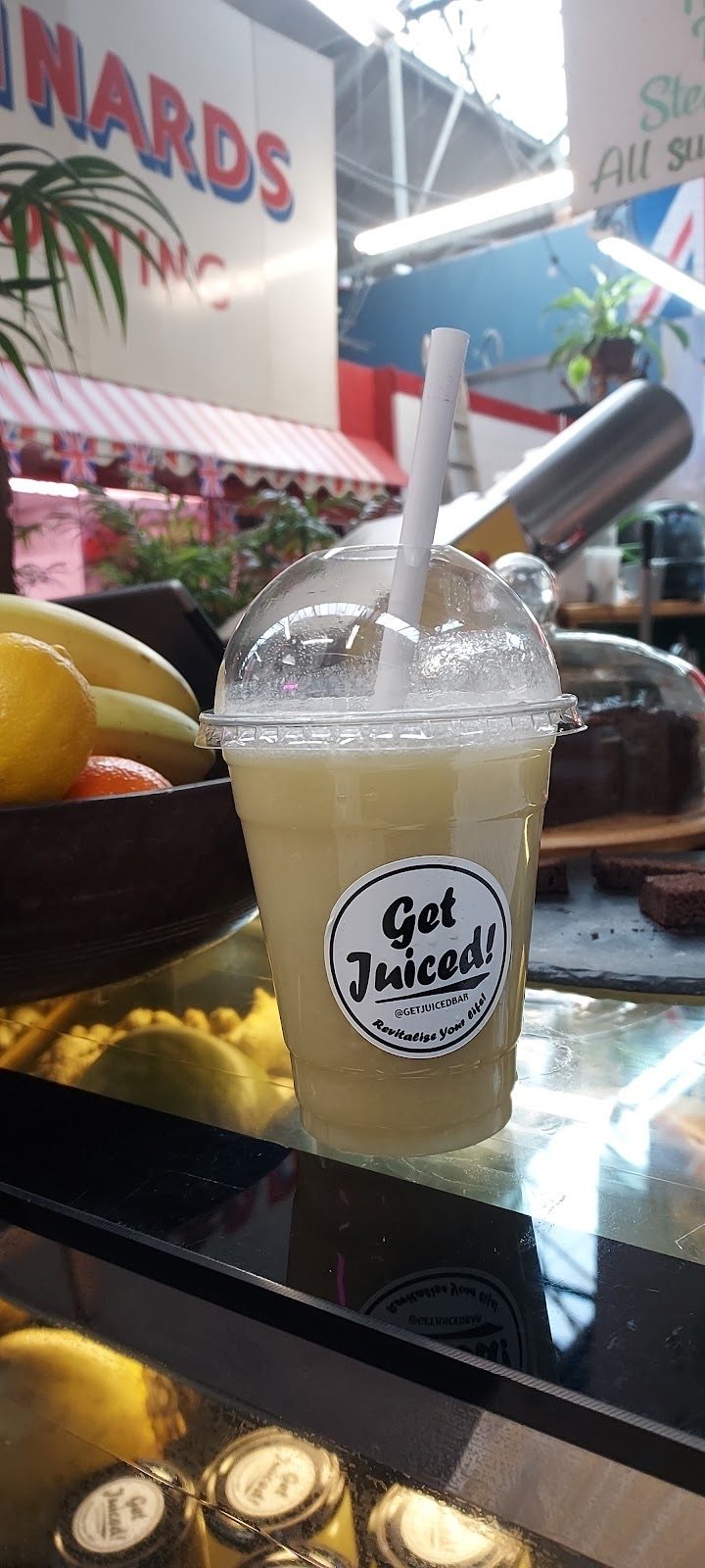 A pale green juice in a cup with a straw